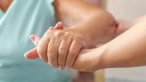 Eine jüngere Frau hält die Hand einer älteren Frau. Seit der Pflegereform von 2017 haben mehr Pflegebedürftige Anspruch auf Leistungen aus der Pflegeversicherung.
