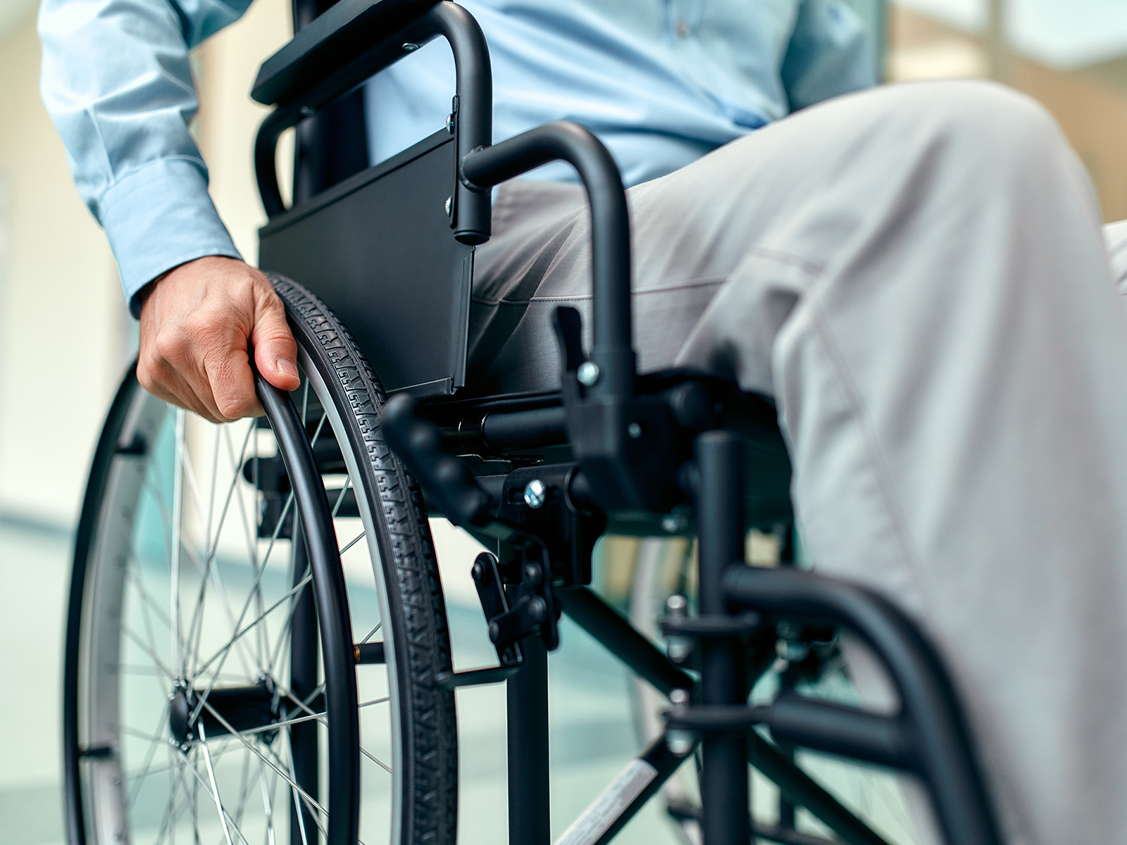 Nahaufnahme eines älteren Mannes, der im Rollstuhl sitzt. Pflegerollstühle gelten als technisches Pflegehilfsmittel.