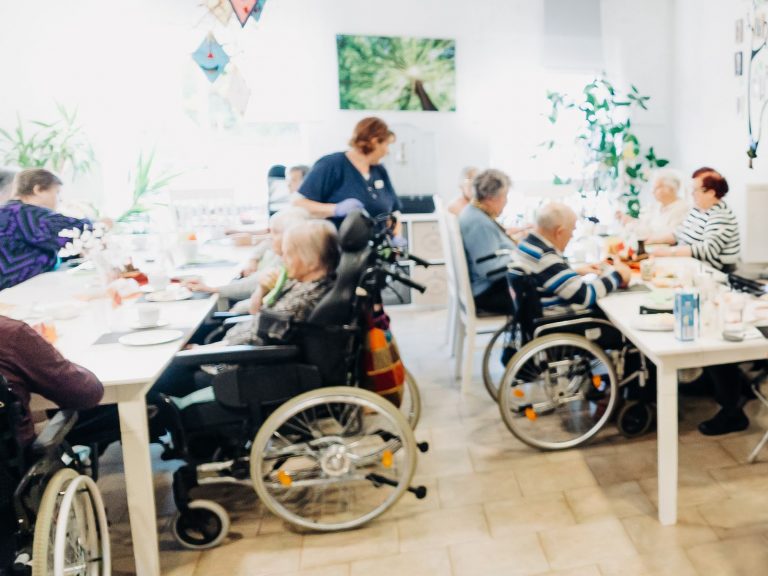 Eine Mitarbeiterin sowie Gäste der Solitas Tagespflege im Speiseraum.
