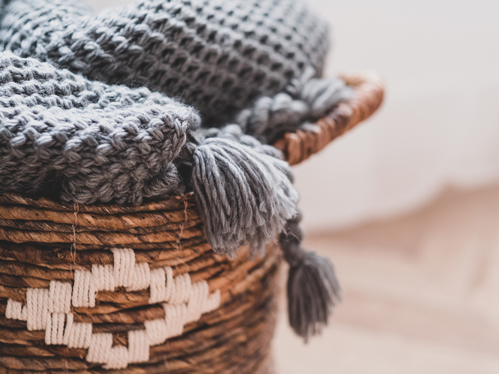 Warme graue Decke in einem braunen Korb
