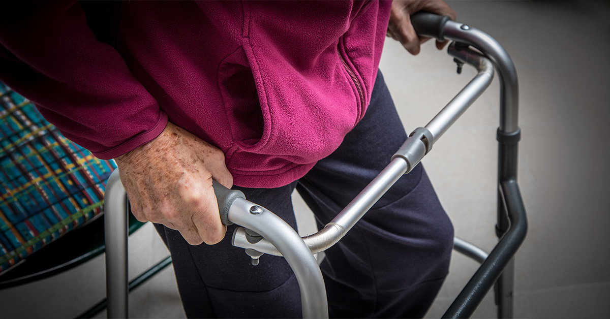 Eine ältere Person schiebt einen Rollator.