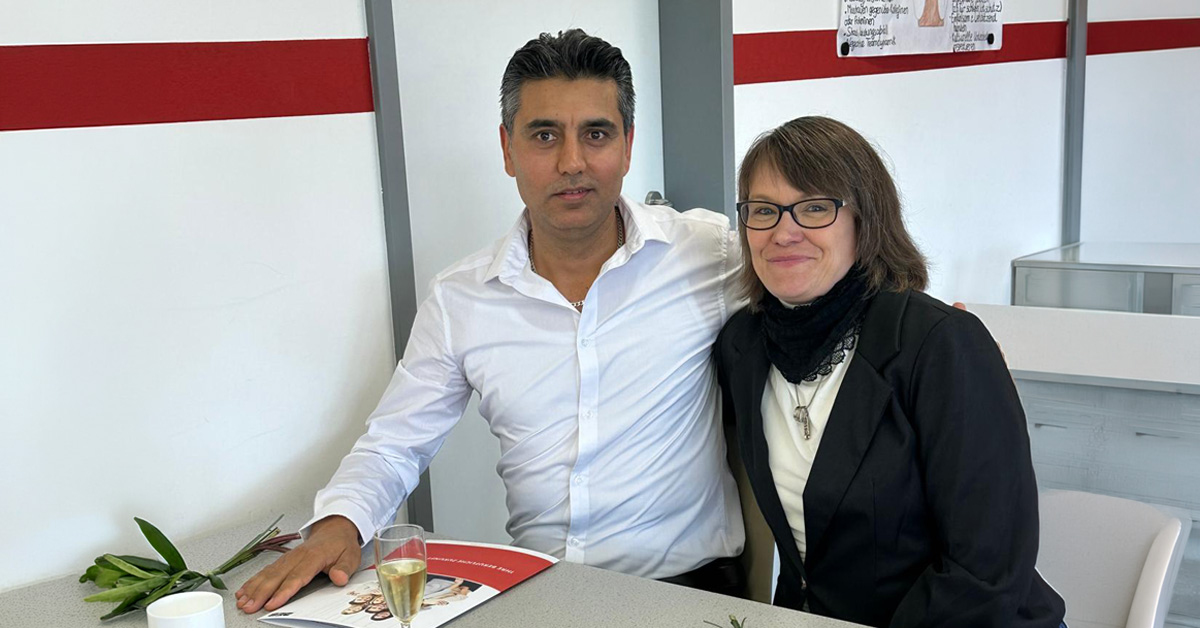 Zwei Mitarbeitende von Solitas Arm in Arm bei der Zeugnisvergabe